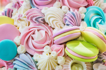 multicolored background of marshmallow sweets, macaroon cakes and cream. Pastel shades of color