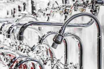 different types of chrome-plated water faucets and taps on the shop window