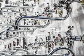 Obraz premium different types of chrome-plated water faucets and taps on the shop window
