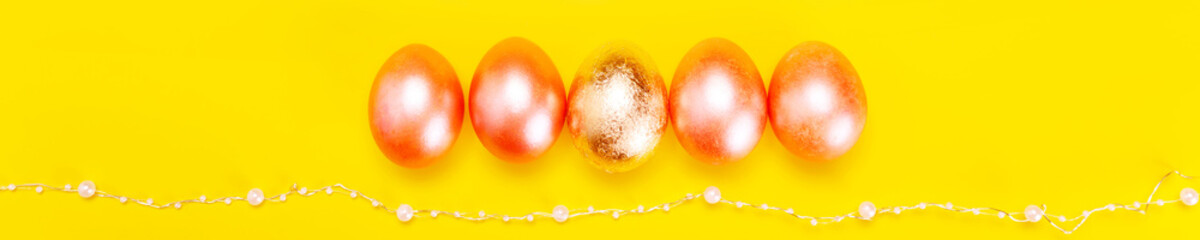 Minimalistic concept of easter holiday with pearl colored eggs over bright yellow