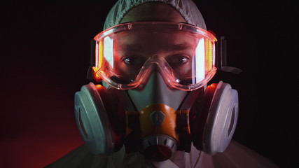 Man in protective costume suit, gas protect medical spray paint mask. Doctor in respirator. Concept...
