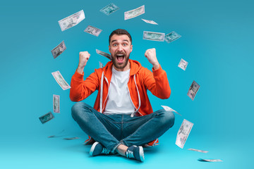 Young attractive bearded man celebrating victory after betting at bookmaker's website - 325946857