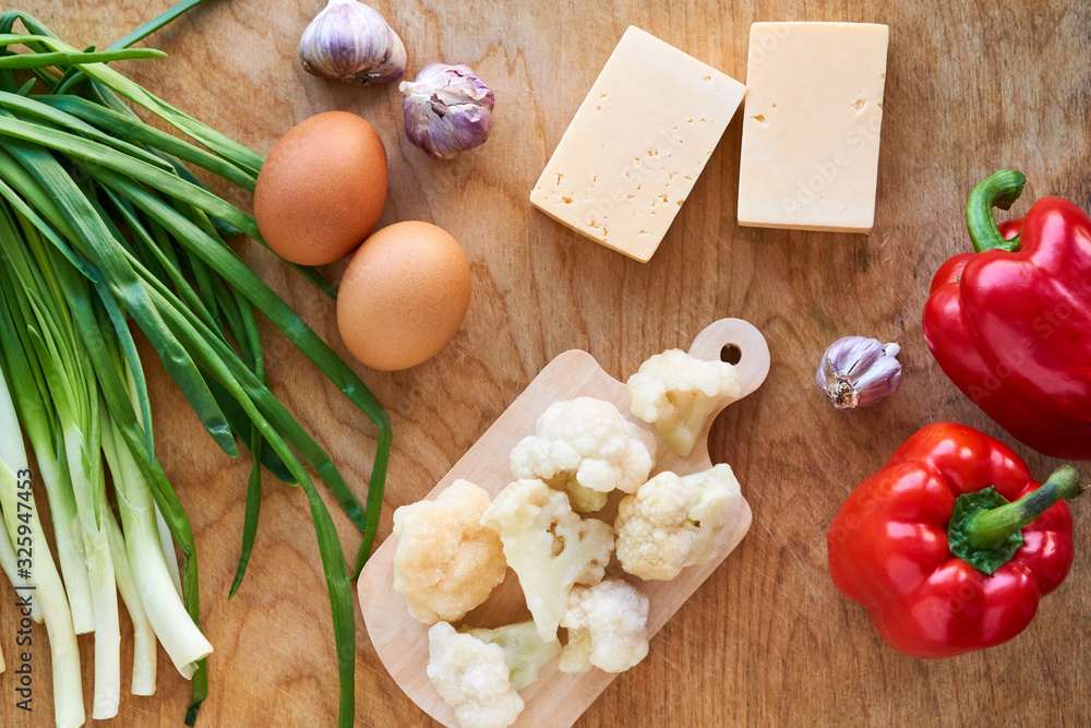 Wall mural Ingredients for cooking cauliflower pizza on a wooden background