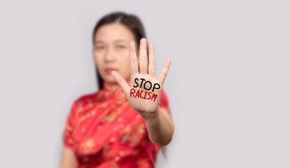 Asian woman in Chinese costume doing stop gesture with palm hand with message stop racism. warning expression with negative and serious gesture.