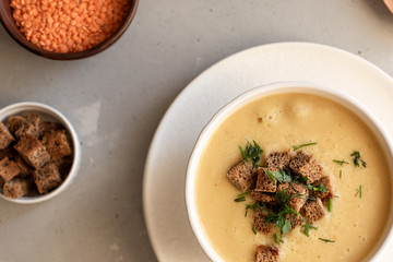 Tomato soup in a black bowl on grey stone background. Top view. Copy space.