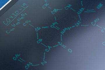 Chemical compound written on blackboard with the headline COVID-19 using as medical research for COVID-19, Corona virus medicine or vaccine