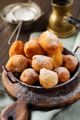 Little Donuts. Homemade curd fried cookies in deep fat and sprinkled with icing sugar in a vintage plate on a light background. Selective focus.