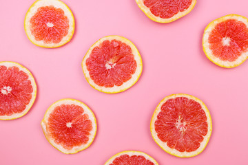 Slices of grapefruit on a pink background
