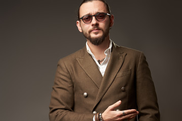 Portrait of serious man in jacket on brown background in studio