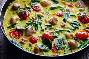 Vegan coconut curry with champignons on a skillet