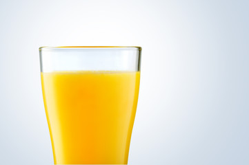 Orange juice in glass on gray background. Summer drink.