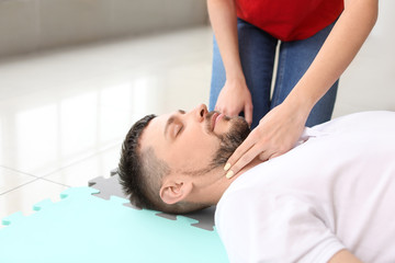 Fototapeta premium Instructor demonstrating CPR on man at first aid training course