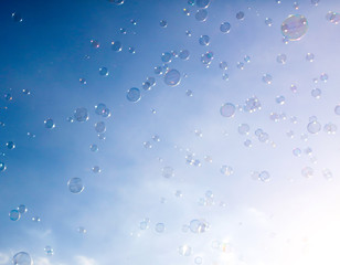 Soap bubbles fly in the blue sky