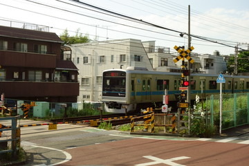 赤色の信号機が点滅している鉄道線路の踏み切り