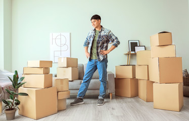 Fototapeta premium Asian man with belongings at home on moving day
