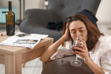 Woman drinking wine at home. Concept of alcoholism