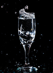 Water with splashes in a glass on a black background