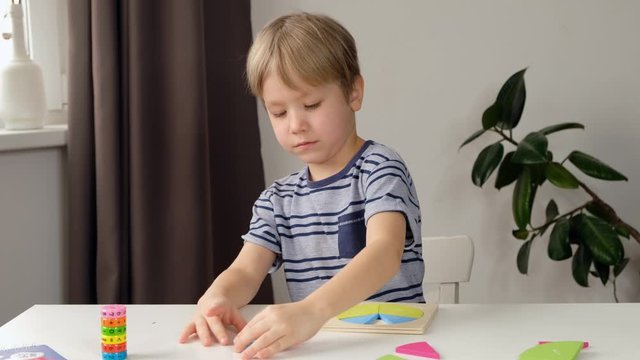 Child boy toddler doing simple math exercises with fractions at school, close up. dividing fractions, mathematics