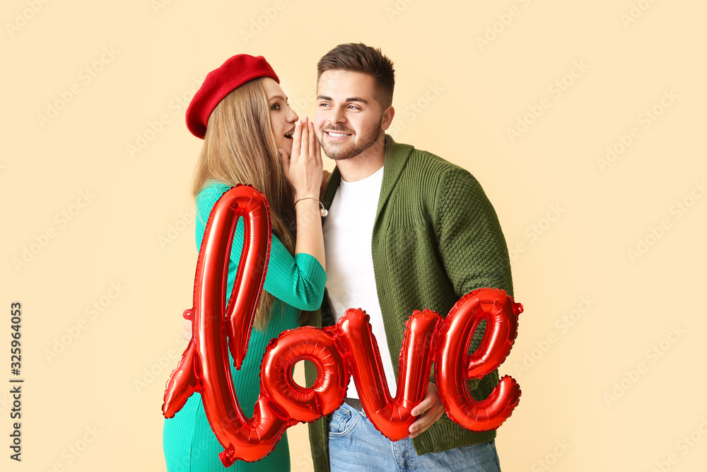 Sticker Happy young couple with air balloon in shape of word LOVE on color background