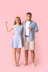 Happy young couple with hearts on color background