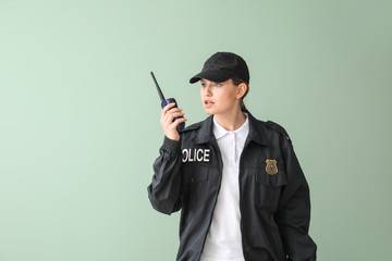 Female police officer on color background