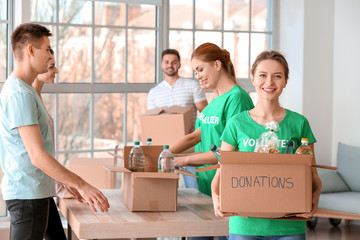 Team of volunteers giving products to poor people