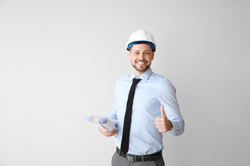 Male engineer showing thumb-up gesture on light background