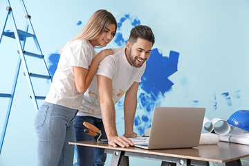 Happy young couple doing repair in their new house