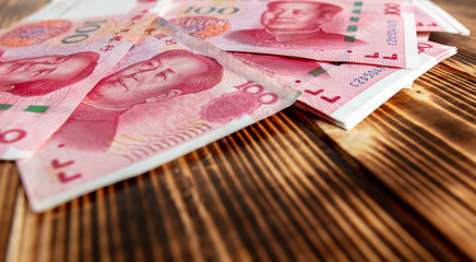 One hundred Chinese yuan on a wooden background