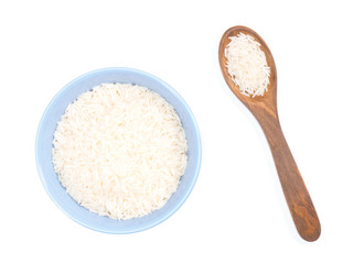 Indian long grain Basmati rice in blue ceramic bowl and wooden spoon isolated on white. Indian cuisine, ayurveda, naturopathy concept