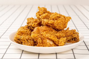 Close Up Fried Chickens on white Plate Isolated on table. Look Yummy and Yellow Gold Color.