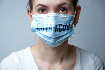 Girl with sick red eyes with a protective mask wearing a coronavirus 2019-NCOV. The concept of the person infected.