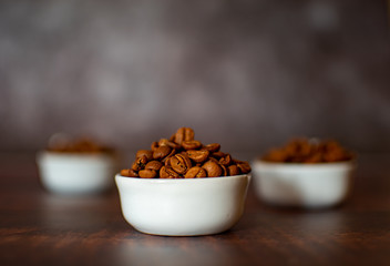 Close-up three bowls roasted coffe beans with bokeh