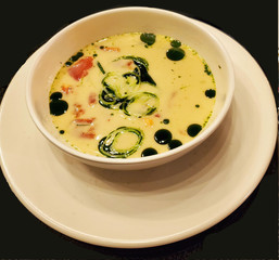 cream soup with salmon, leek, spinach  in  white plate on a black background. Lunch, snack, proper nutrition, seafood