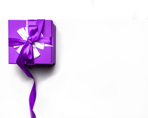 Purple gift box with bow and ribbon on a white background, isolated image