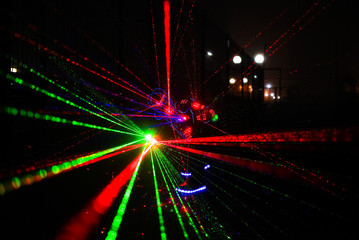 Fototapeta na wymiar multi-colored laser beams. man laserboy. laser lines in the dark