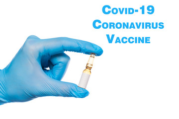 Surgeon's hand in a blue medical glove holds an ampoule with medicine isolated on white background