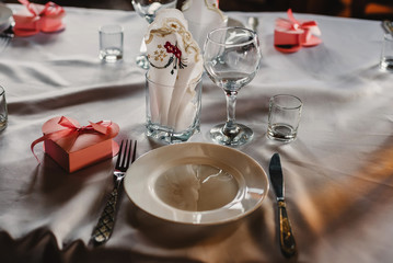 set of empty glasses and plates with Cutlery on a white tablecloth on the table in the restaurant