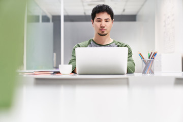 Junger Mann als Programmierer am Laptop Computer