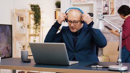 Senior old man listening music on headphones