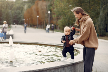 Fototapeta premium Family in a autumn park. Mother in a warm sweater. Cute little child