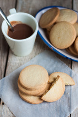 Top view of freshly baked cookies and hot chocolate cup on wooden table