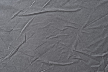 Abstract pattern of a gray crumpled bed sheet in bedroom. Gray wrinkled fabric texture rippled surface, Close up bed sheet in the bedroom.