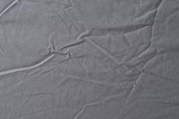 Abstract pattern of a gray crumpled bed sheet in bedroom. Gray wrinkled fabric texture rippled...