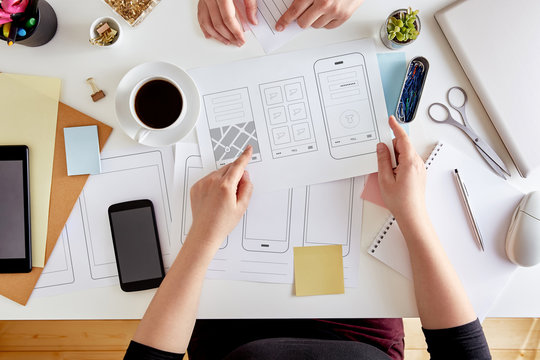 UX graphic designers planning out the structure of a mobile application. Wireframing stage of a web mobile phone. User experience concept. Flat lay - Powered by Adobe