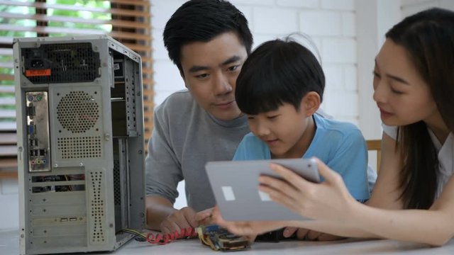 Learning concepts. Parents are encouraging their sons to learn to repair computers. 4k Resolution.