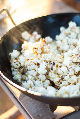 Frying pan with freshly made popcorn at sunset
