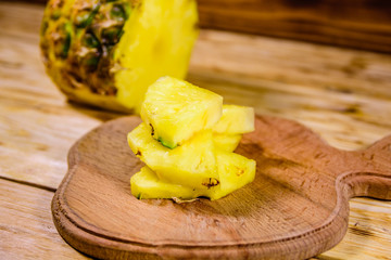 Cutting board with sliced pineapple on wooden table