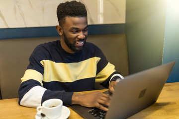 African-american man using laptop studying on computer in public place