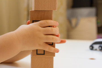 Wooden tower of cubes on a white table. concept of early childhood development. children's toys made of wood. School and kindergarten. Logical educational toys. the child is playing.
